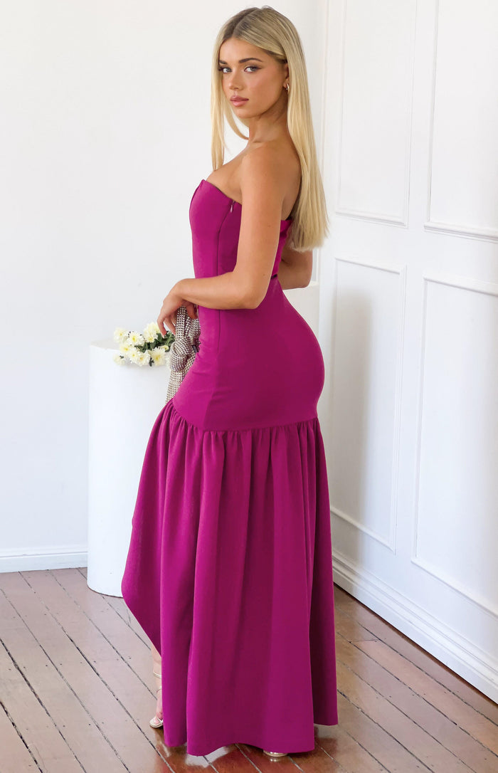 Side view of a berry crepe strapless maxi dress with a fitted bodice and gathered frill skirt detail