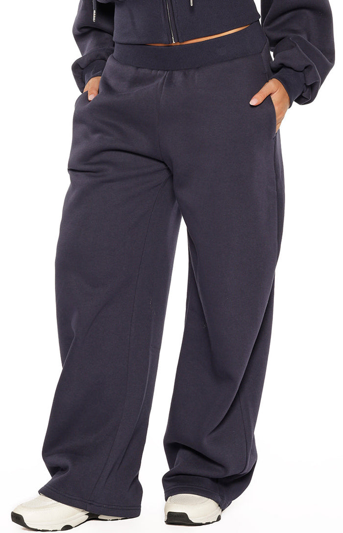 Navy barrel leg track pants with elasticated waistband, side pockets, and curved leg seam detail