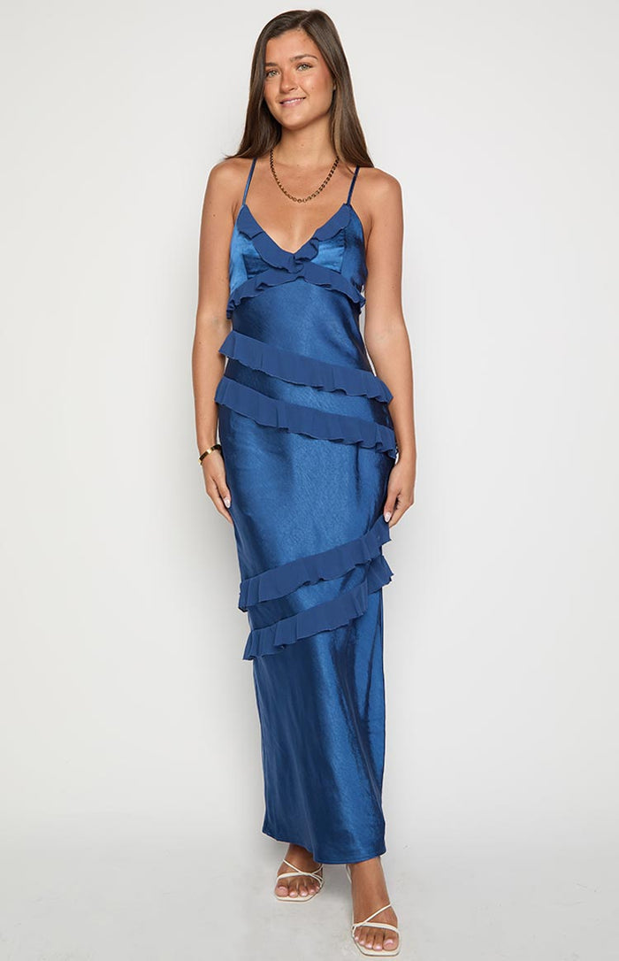Front view of a navy satin maxi dress with a V-neckline and tiered ruffles across the bodice and skirt
