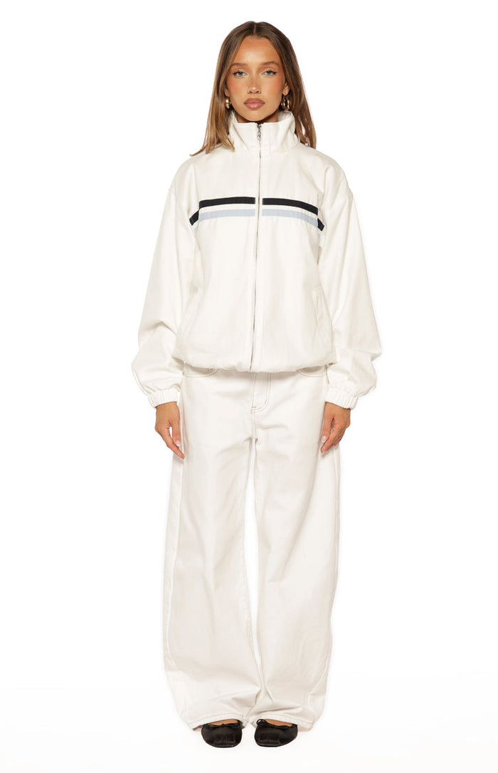 Full front view of a cream funnel neck jacket with black and light blue chest stripes, elasticated cuffs and hem