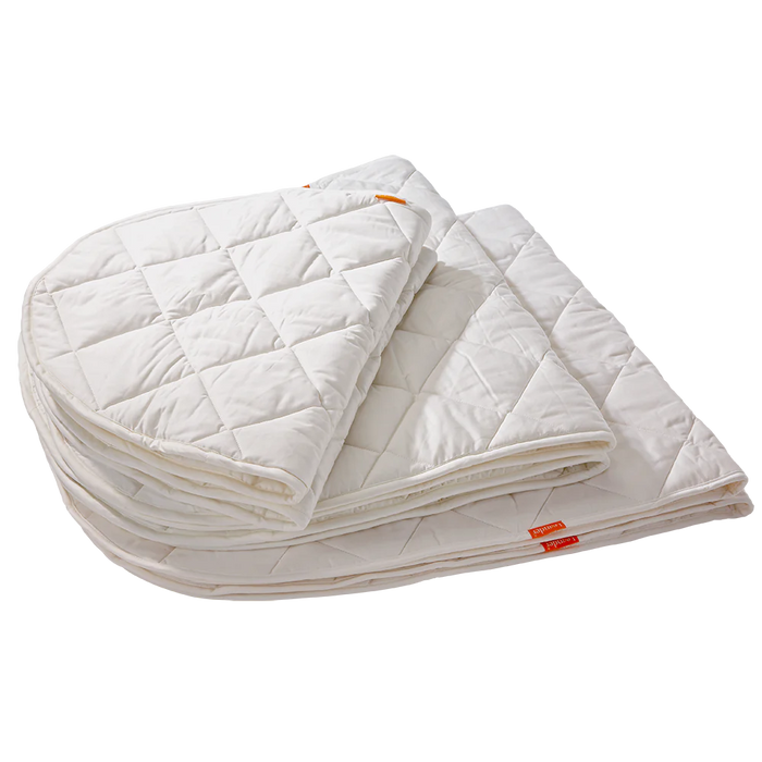 Folded white quilted Leander Classic Cot organic mattress protector for baby strollers