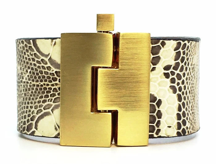 Wide bracelet with gold clasp and snake skin pattern on a white background