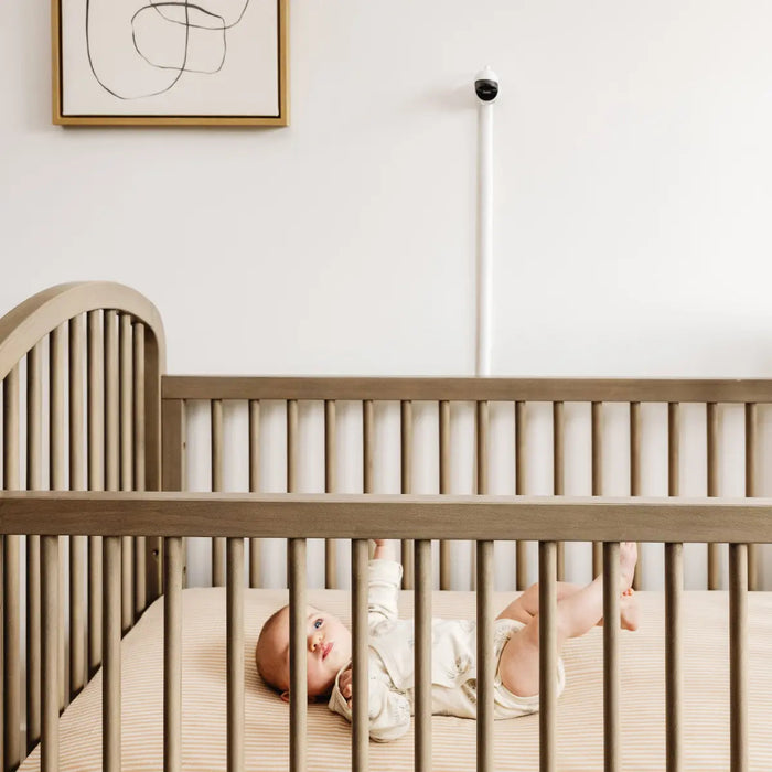 Baby in a wooden crib seen with Owlet Cam 2 White, Toshi Baby Romper, bare mum postpartum