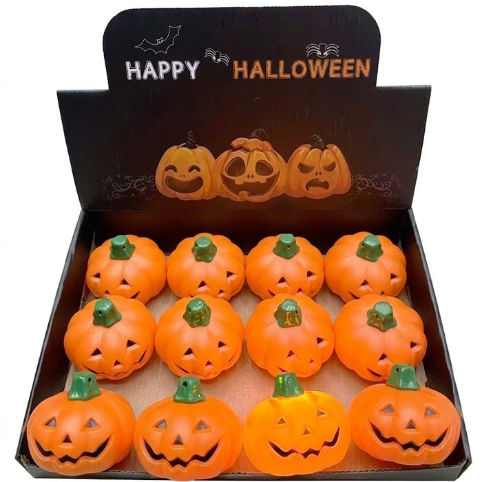 A boxed set of 12 small orange jack-o'-lantern Halloween decorations arranged in a black display tray with a black 'Happy Halloween' header card.