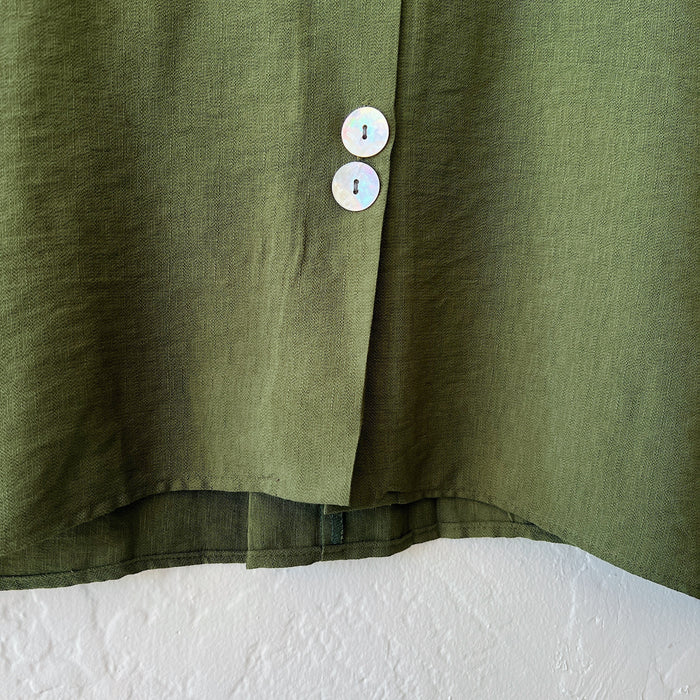Close-up of a green shirt with buttons on a white background