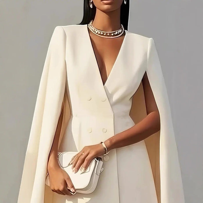 Woman wearing a white cape over a plain background