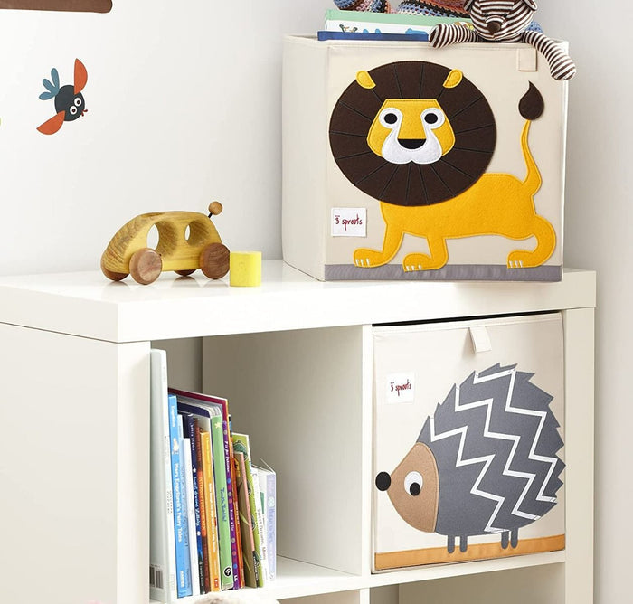 Children's storage boxes with animal designs on a shelf with books and toys.