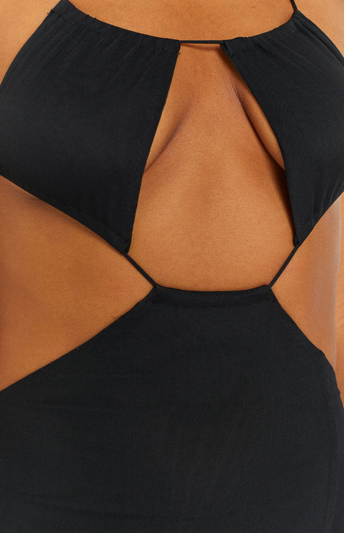 Close-up of the black stretch knit midi dress with geometric chest and side cutouts connected by thin straps