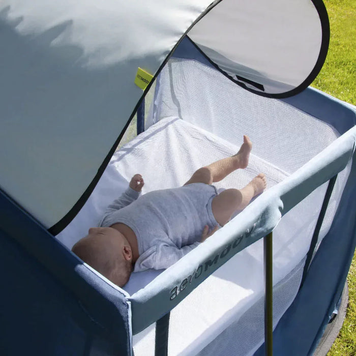 Baby in portable bassinet under Aeromoov Sunshade UV50+ with toshi baby romper, perfect for baby strollers