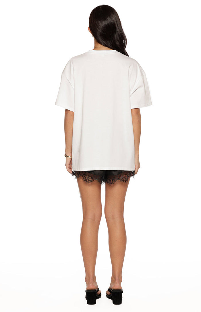 Rear view of the white oversized short sleeve tee with a relaxed fit and straight hem