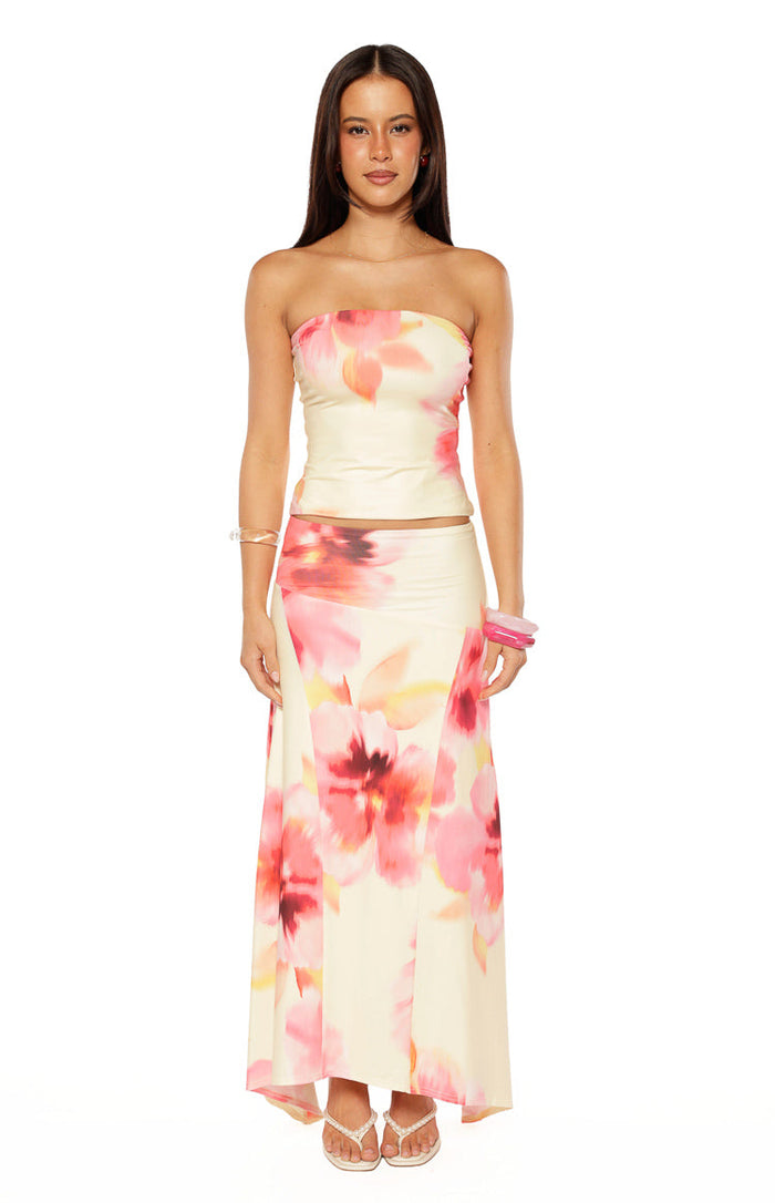 Full front view of a yellow and pink floral print maxi skirt with a flowing silhouette and hanky hem