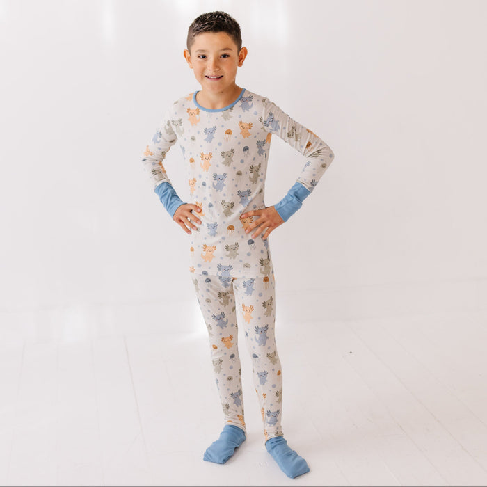 Child wearing a patterned pajama set with blue accents on a white background
