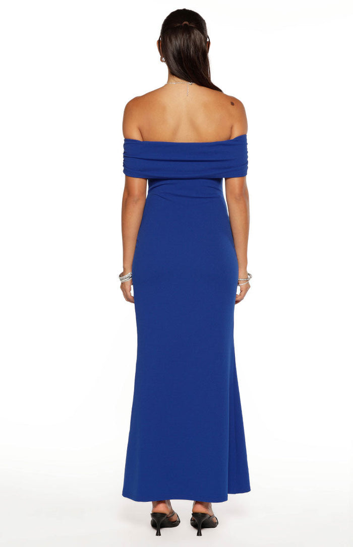 Rear view of a cobalt blue crepe maxi dress with a draped off-shoulder neckline and a fitted silhouette