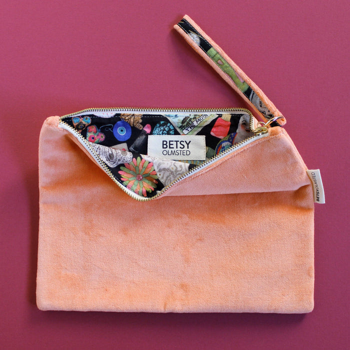 Pink clutch bag with floral patterned interior on a pink background