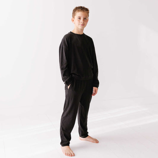 Child wearing a black pajama set on a white background