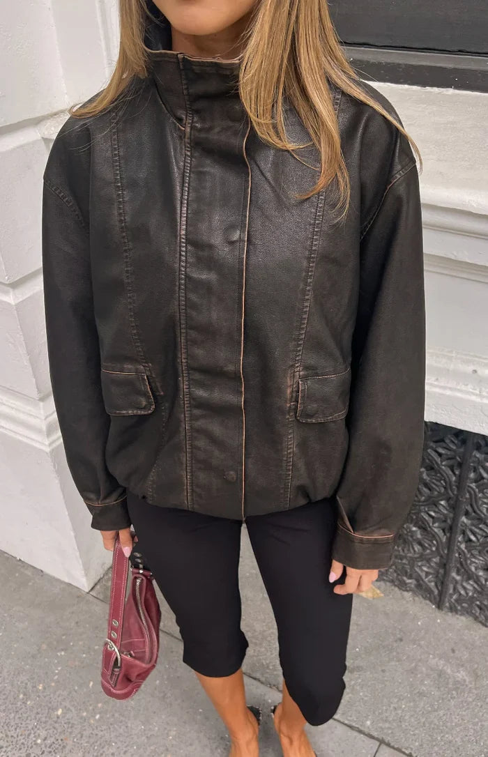Distressed brown PU jacket with a high funnel neck, button placket, and two front flap pockets