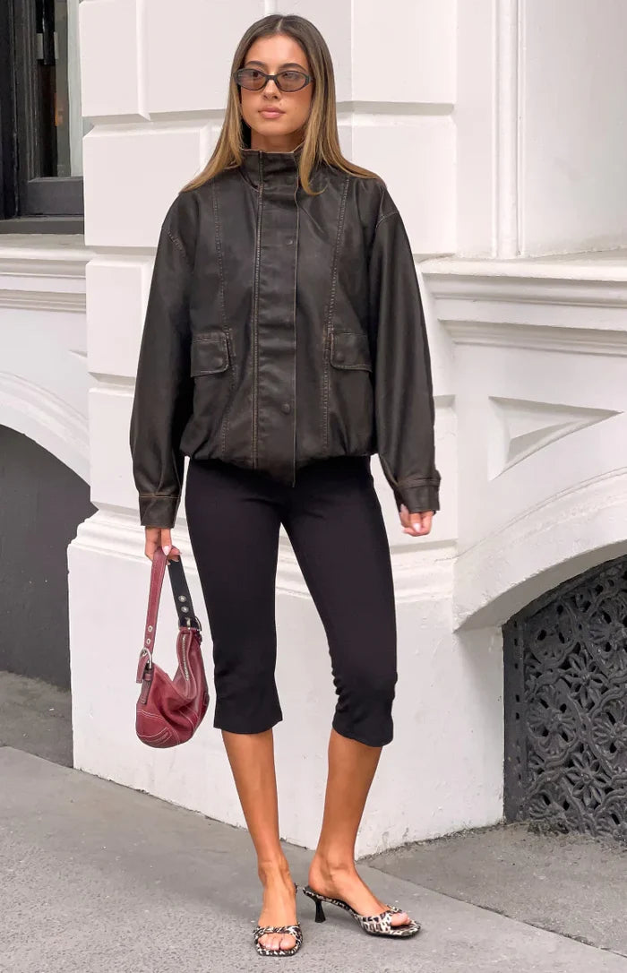 Front view of a brown PU funnel neck jacket with flap pockets and an elasticated hem