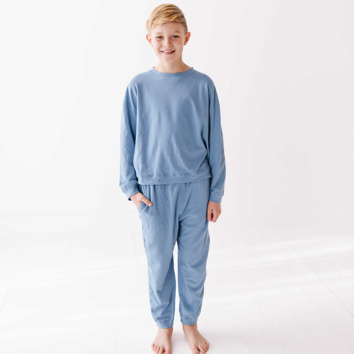 Young boy wearing light blue pajamas on a white background
