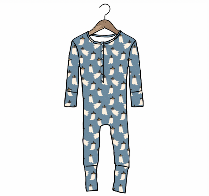 A long-sleeve baby jumpsuit in dusty blue with an all-over white ghost pattern, hanging on a wooden hanger against a plain white background.