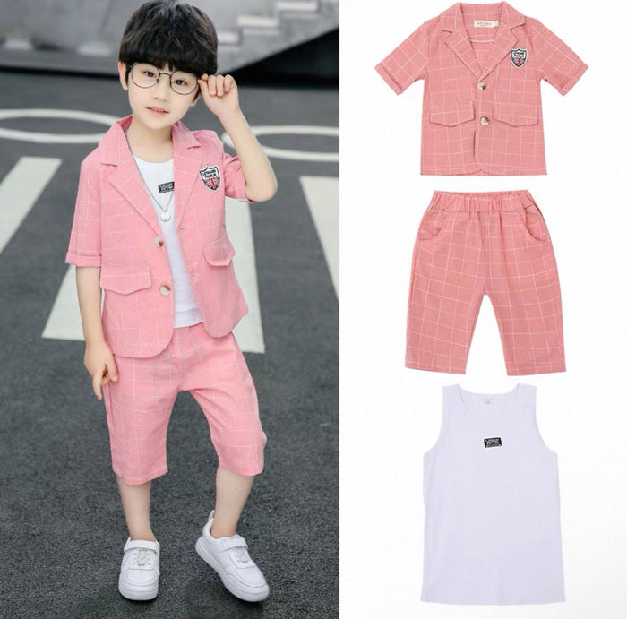 Child wearing a pink outfit with a matching shirt, vest, and pants on a road.