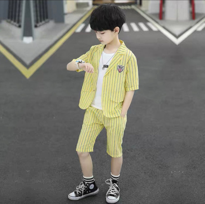 Child wearing a yellow striped outfit standing on a road.