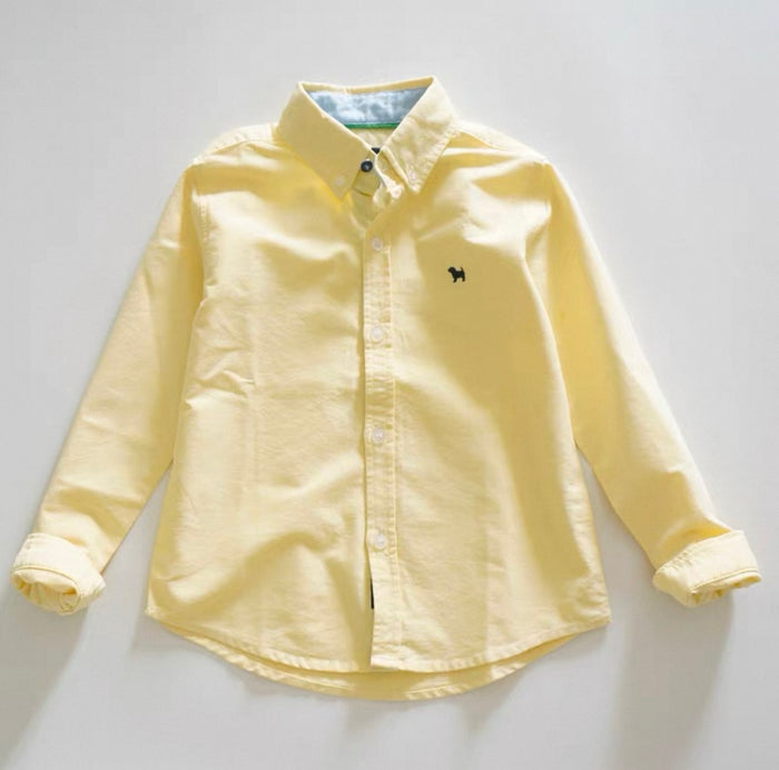 Yellow shirt with a small logo on a light gray background