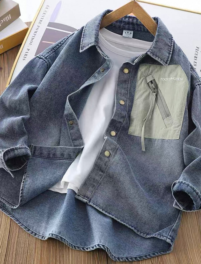 Denim jacket with a white shirt underneath on a wooden surface.
