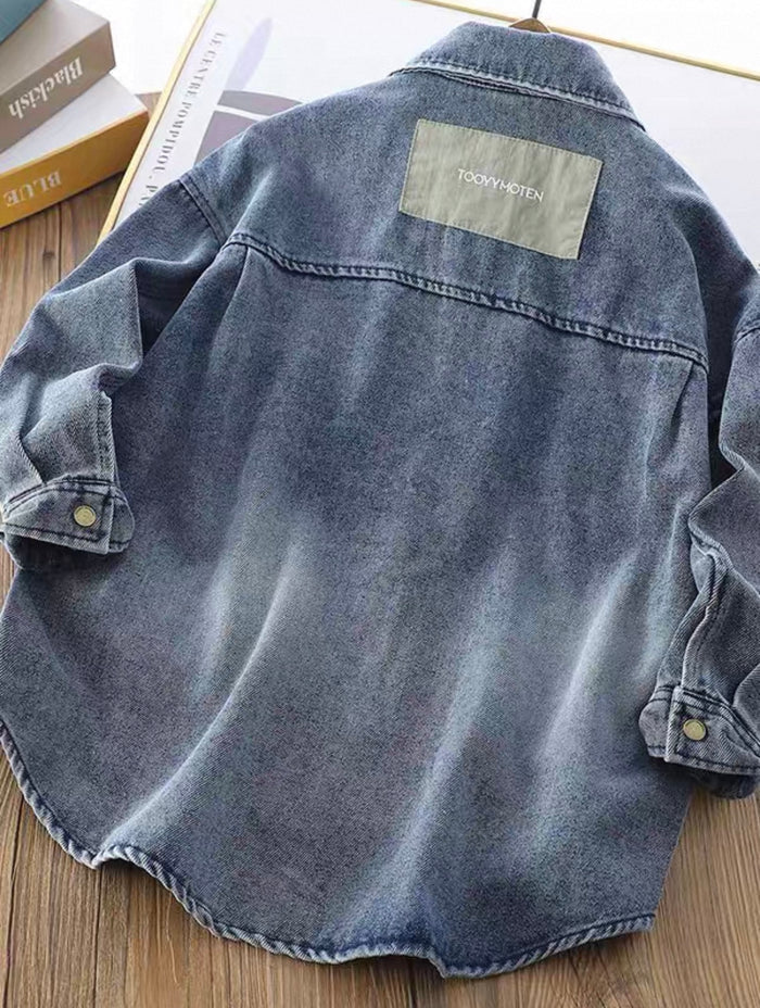 Blue denim jacket with a brand label on a wooden surface