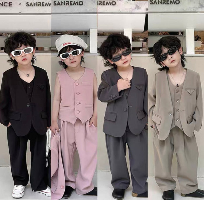 Four children in formal suits and sunglasses posing in a store setting.