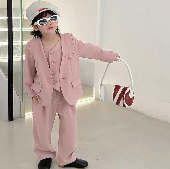 Child wearing a pink suit and holding a bag in a minimalistic setting