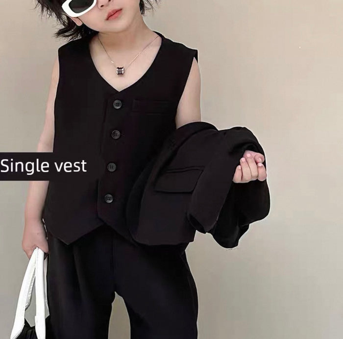 Person wearing a black vest over a black shirt with a plain background