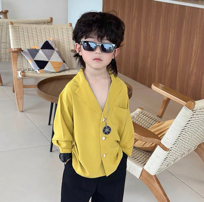 Child wearing sunglasses and a yellow shirt in a room with wooden furniture.