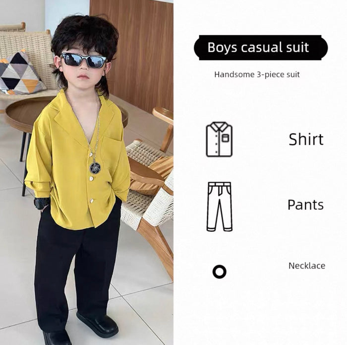 Child wearing a yellow shirt, black pants, and sunglasses indoors.