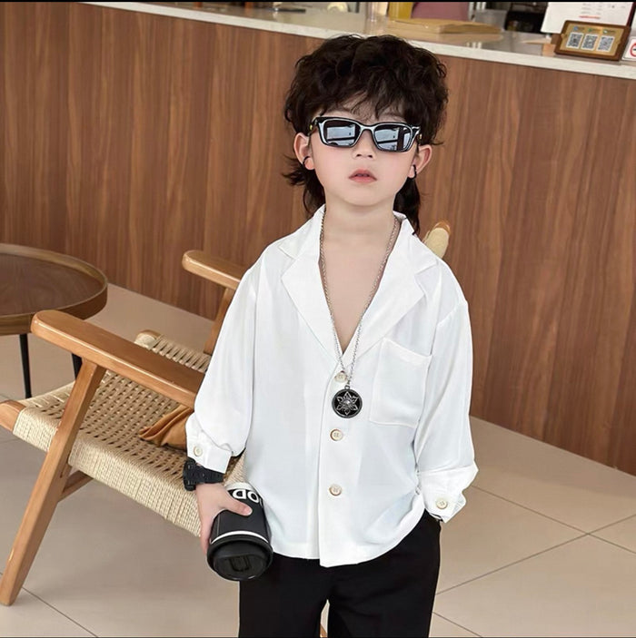 Child wearing sunglasses and a white shirt in an indoor setting