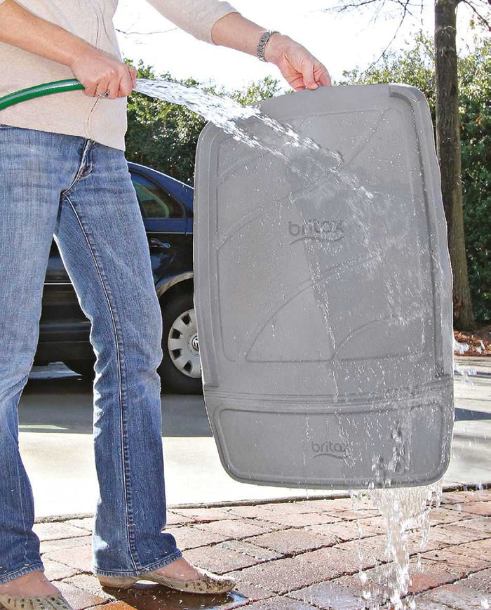 Gray Britax Safe-n-Sound Ultimate vehicle seat protector being hosed down outdoor fun