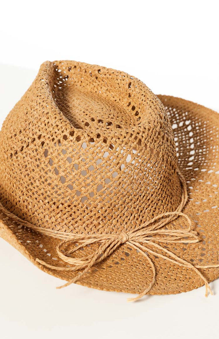 Close-up of the tan open-weave straw western hat with a straw tie band and bow detail
