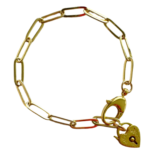 Gold chain bracelet with a heart-shaped padlock charm on a white background