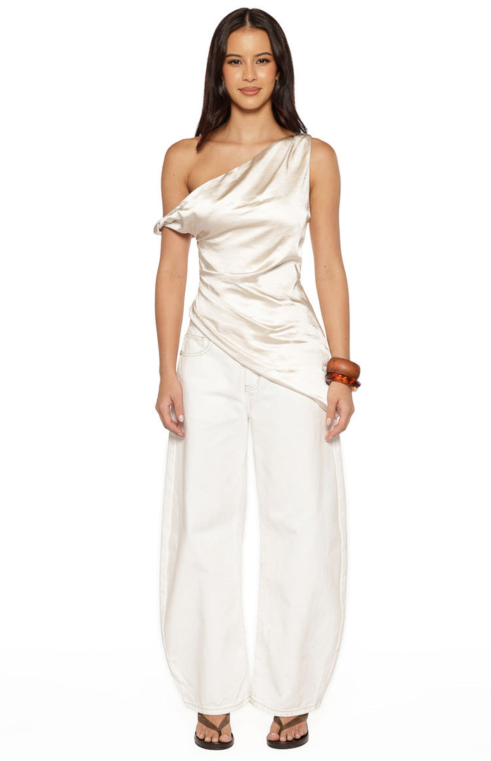 Front view of the cream satin asymmetric top showing the draped bodice and uneven hemline