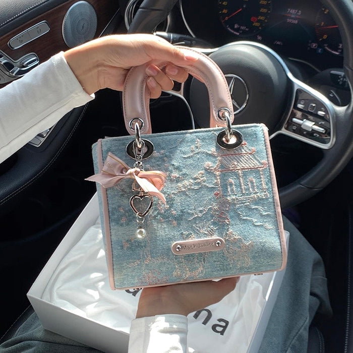 Handbag with decorative bow held inside a car