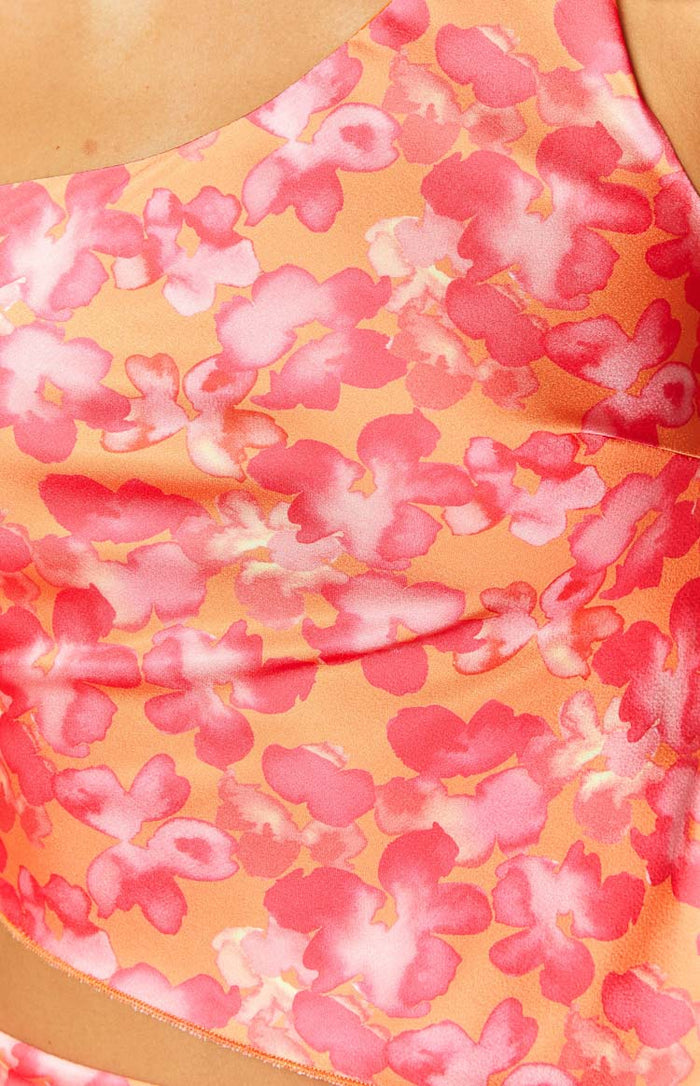 Close-up of the orange and pink floral pattern on the satin top, showing soft gathers