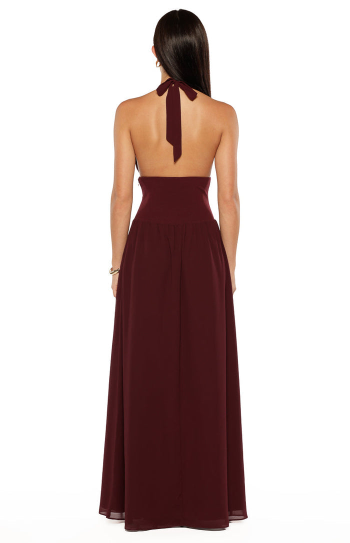 Rear view of the burgundy maxi dress with a halter neck tie, low open back, and high ruched waist