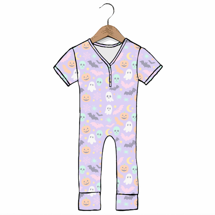 A short-sleeve baby jumpsuit with a light purple background and a Halloween print featuring ghosts, pumpkins, bats, and moons, hanging on a wooden hanger against a white background.