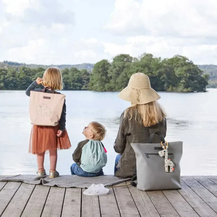 Family with backpacks by a lake featuring the stylish deer changing backpack for toshi baby and baby strollers