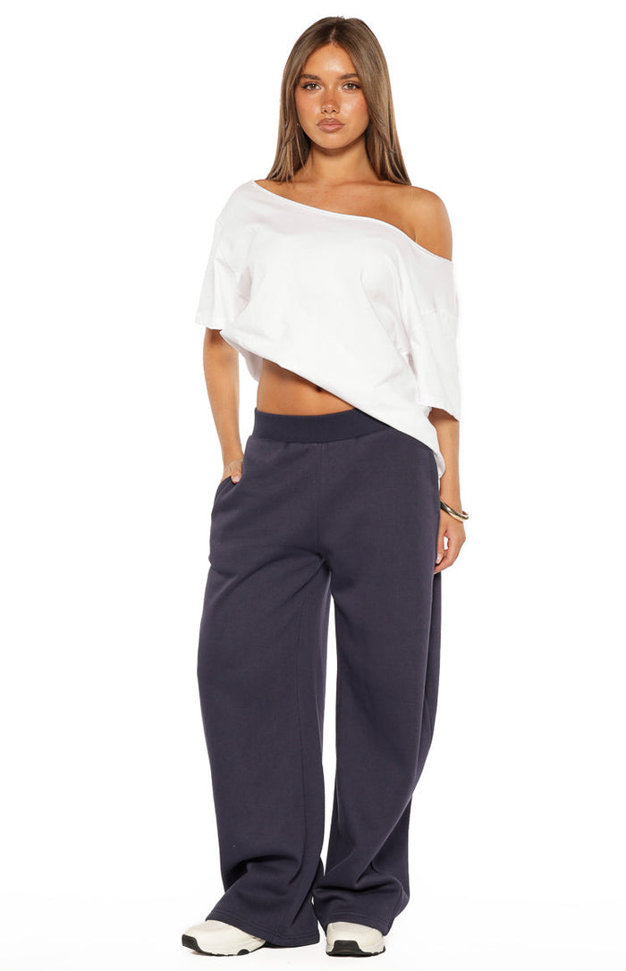 Full front view of navy barrel leg track pants with a relaxed fit and elasticated waistband