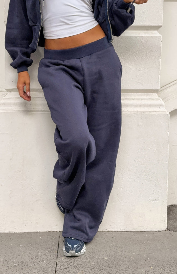 Navy barrel leg track pants with a wide elastic waistband and relaxed, full leg shape