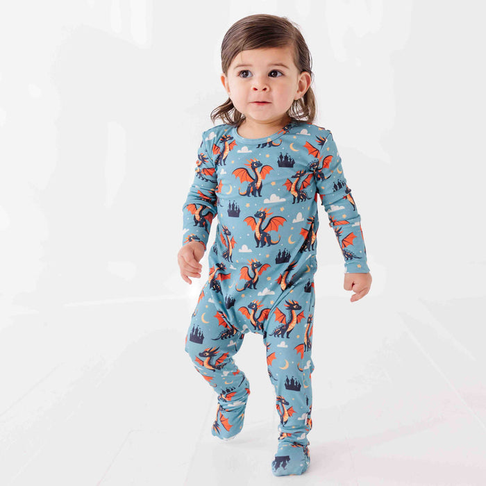 Child wearing a blue pajama set with dragon design on a white background