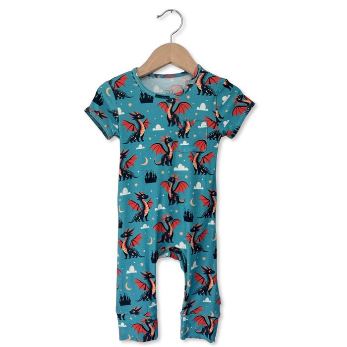 Children's romper with dragon pattern on a hanger against a white background