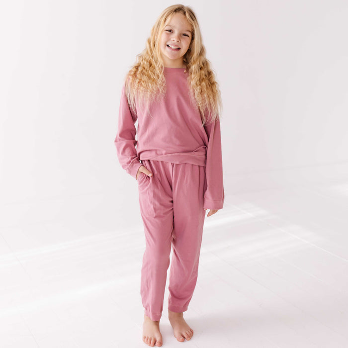 Young girl wearing pink pajamas on a white background