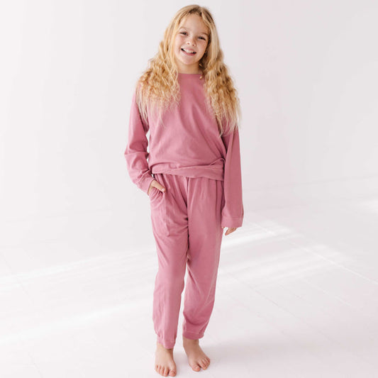 Young girl wearing pink pajamas on a white background