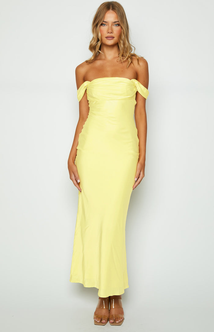 Light yellow off-shoulder maxi dress with a draped bodice and a smooth, flowing skirt